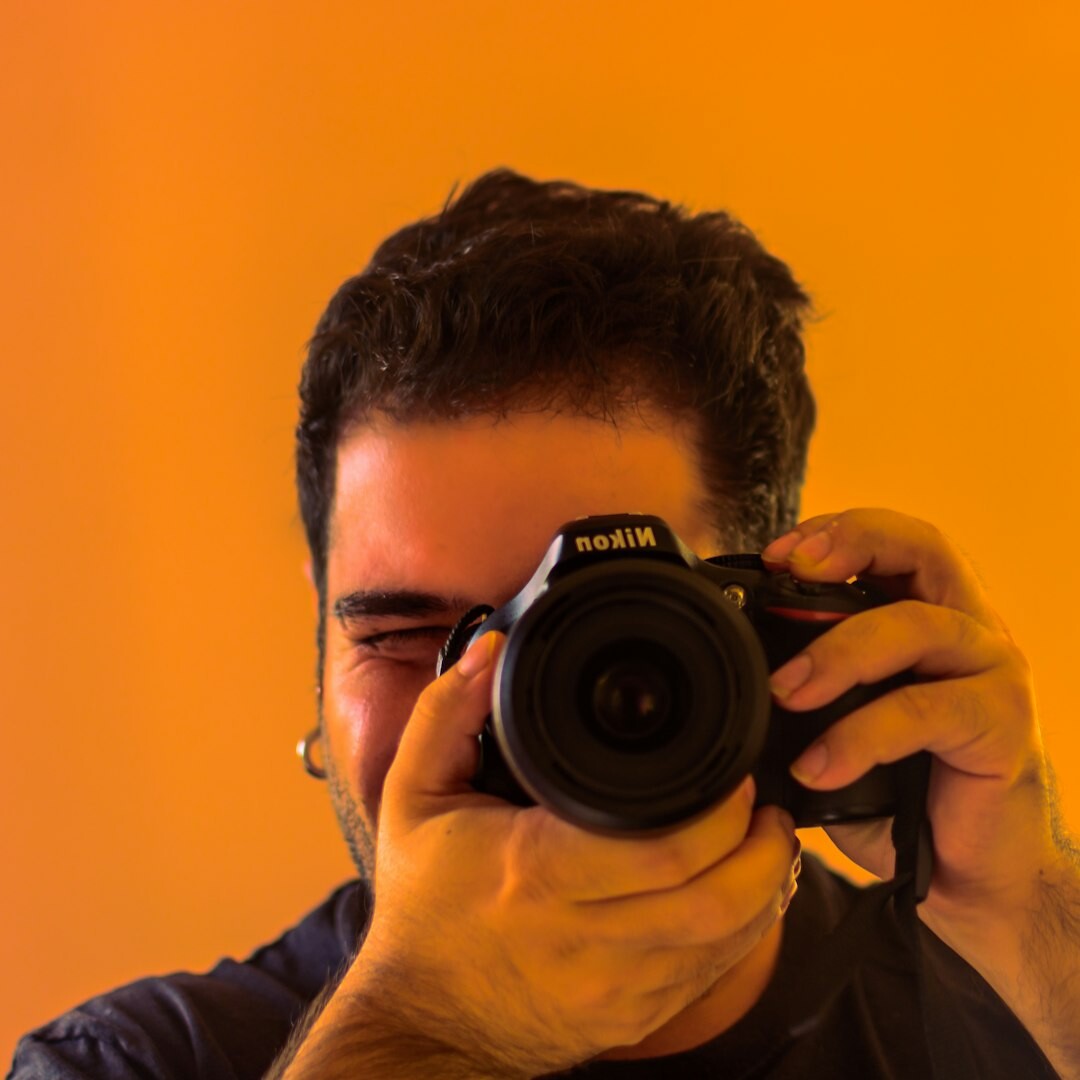 Studio portrait of a Lithuanian male photojournalist holding a camera
